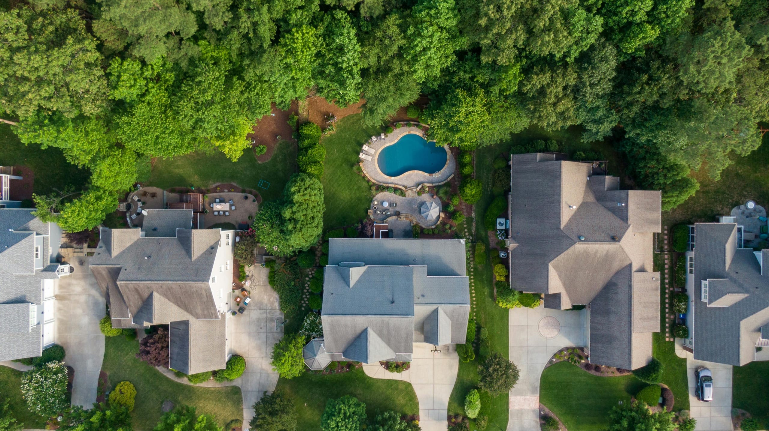 Aerial view of an upscale residential neighborhood with manicured lawns and pools